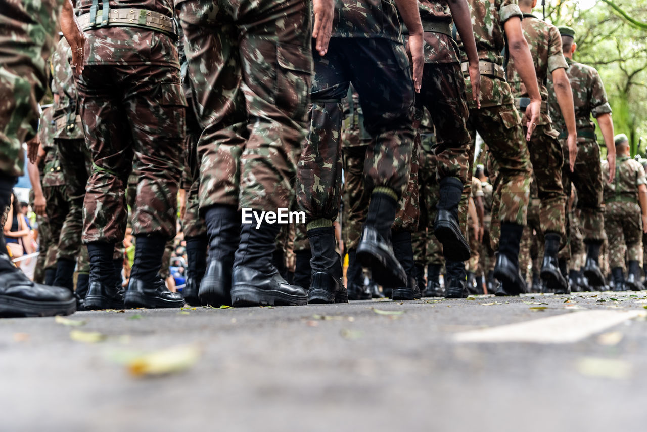  low view of the legs of brazilian army soldiers marching through the streets 
