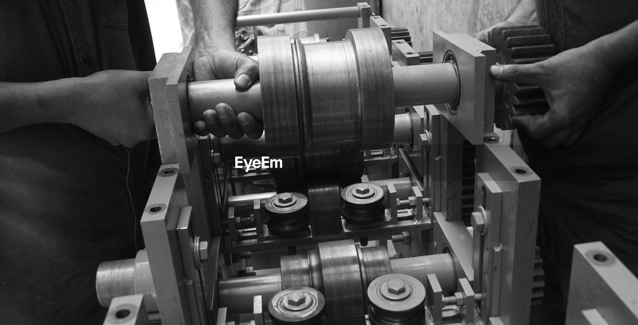 cropped hand of man repairing machine part