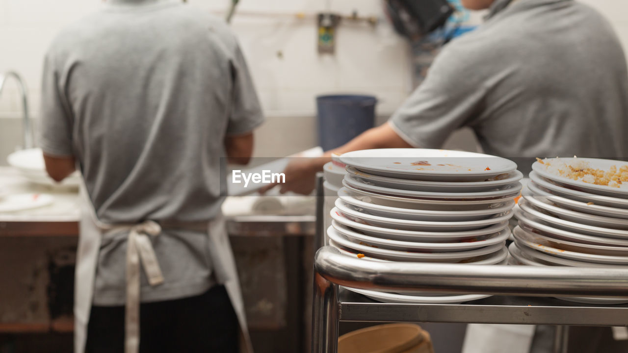 MIDSECTION OF WOMAN STANDING IN RESTAURANT