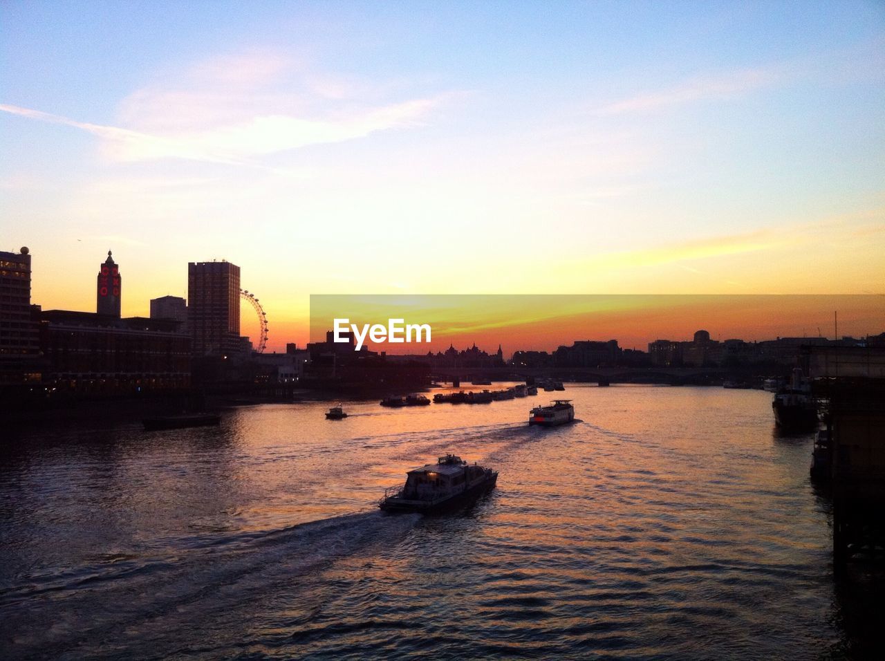 Boats on river at sunset