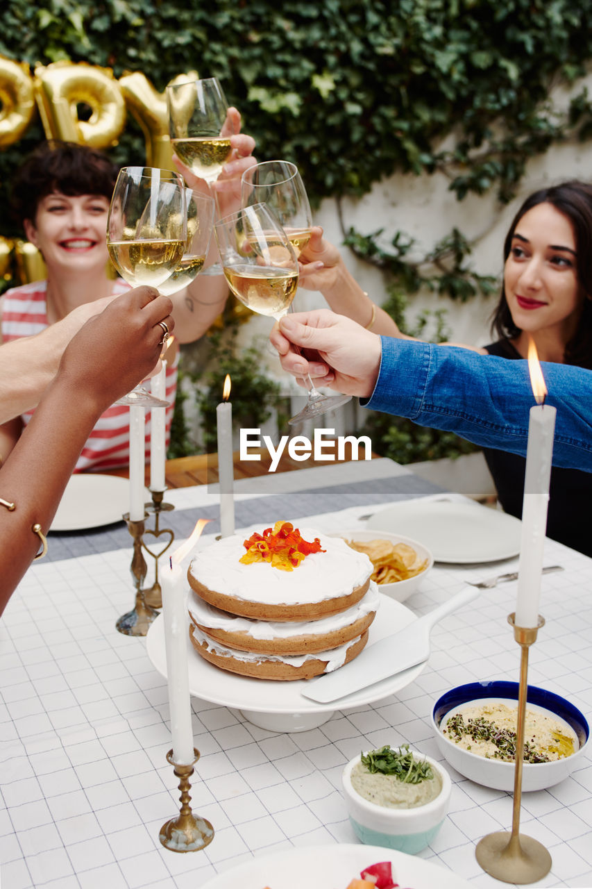 Cropped hands of friends toasting wines