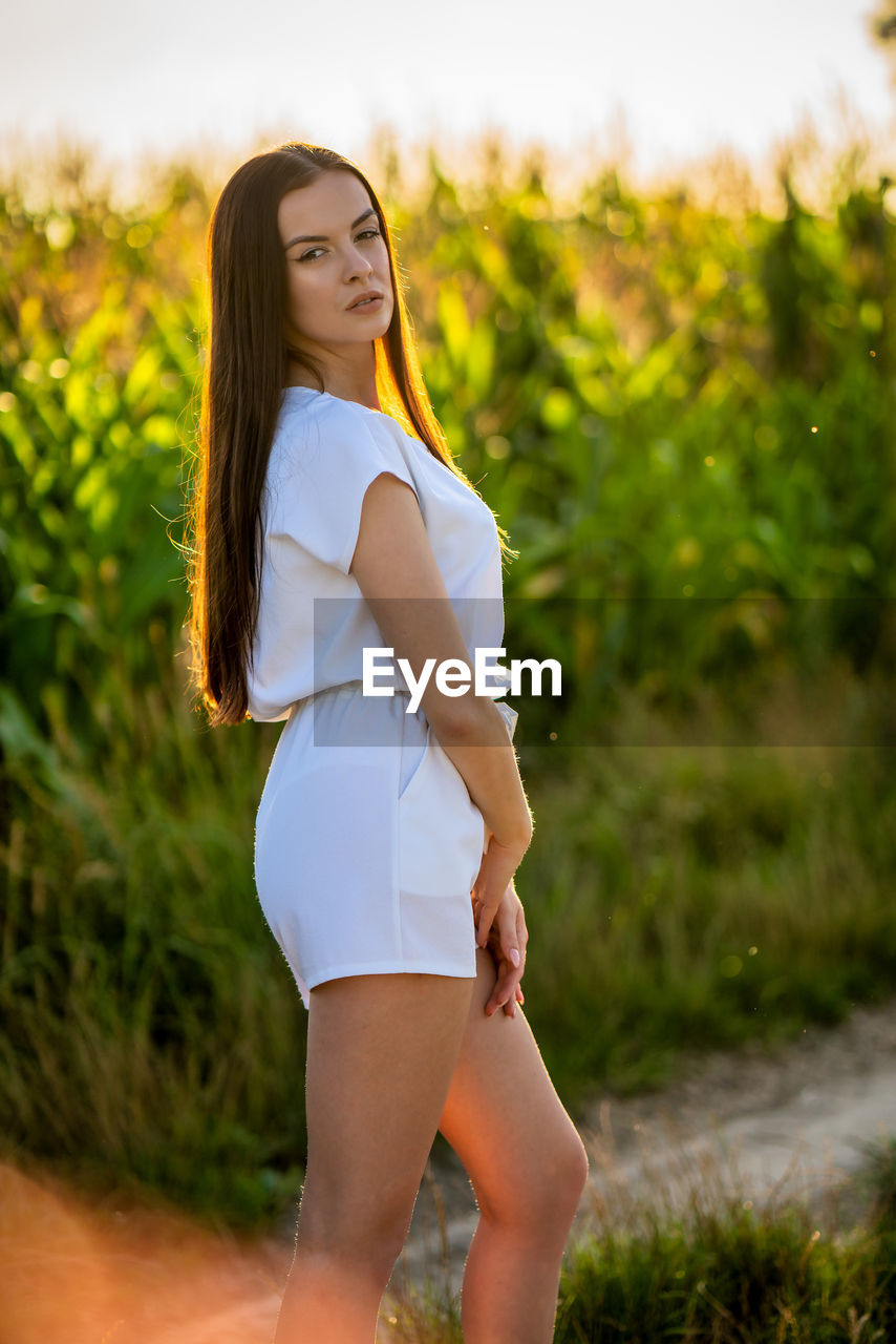 Portrait of young woman standing on field