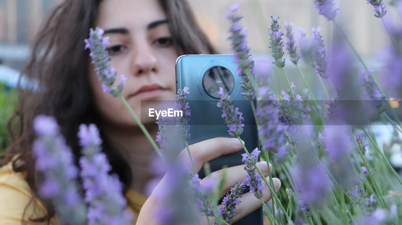 Portrait of beautiful woman photographing in park