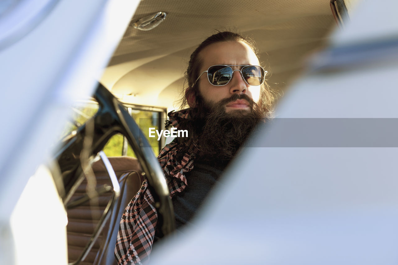 Handsome young man sitting in a car