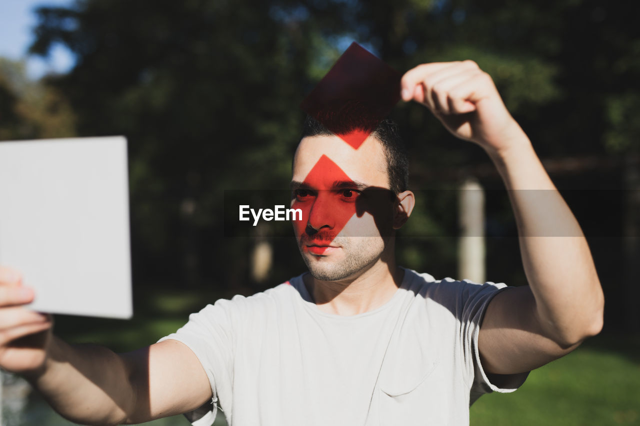 Young man with red reflection on eyes