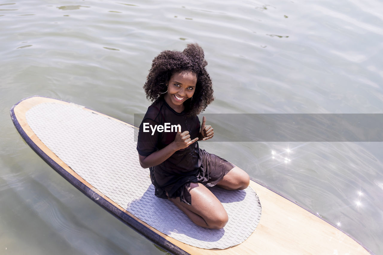 High angel view of woman sitting on paddleboard in lake