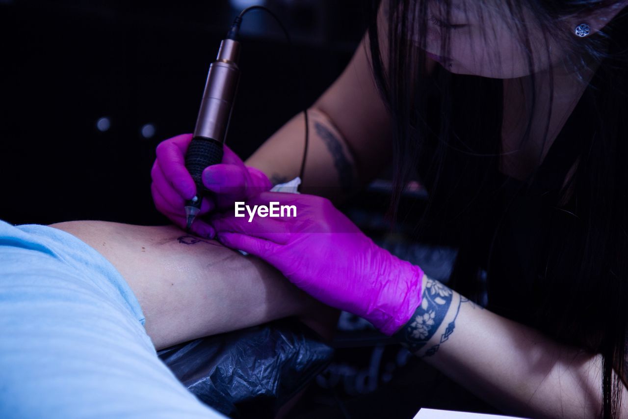 Close-up of tattoo artist tattooing man