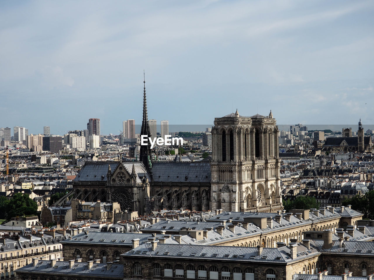 Buildings in city against cloudy sky