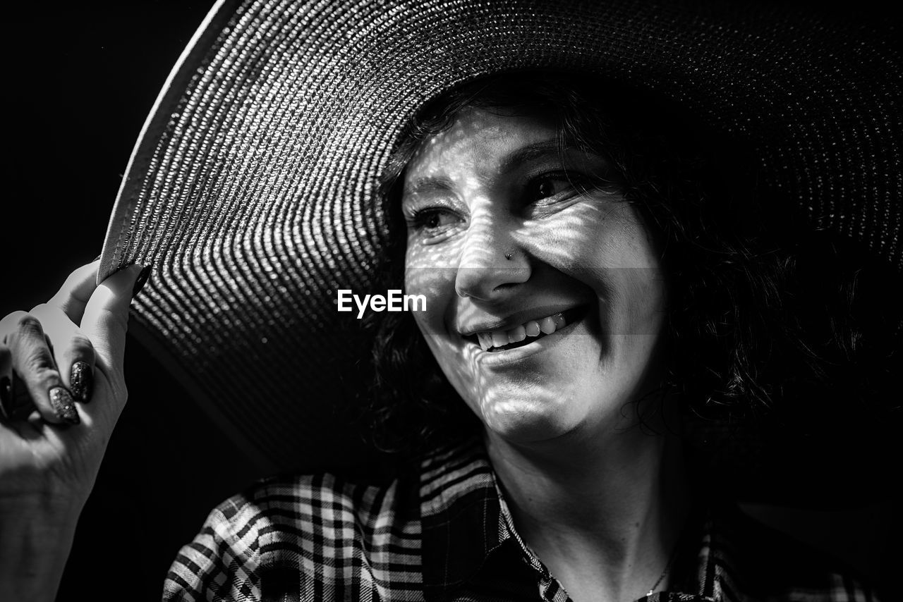 Close-up of smiling woman standing in darkroom