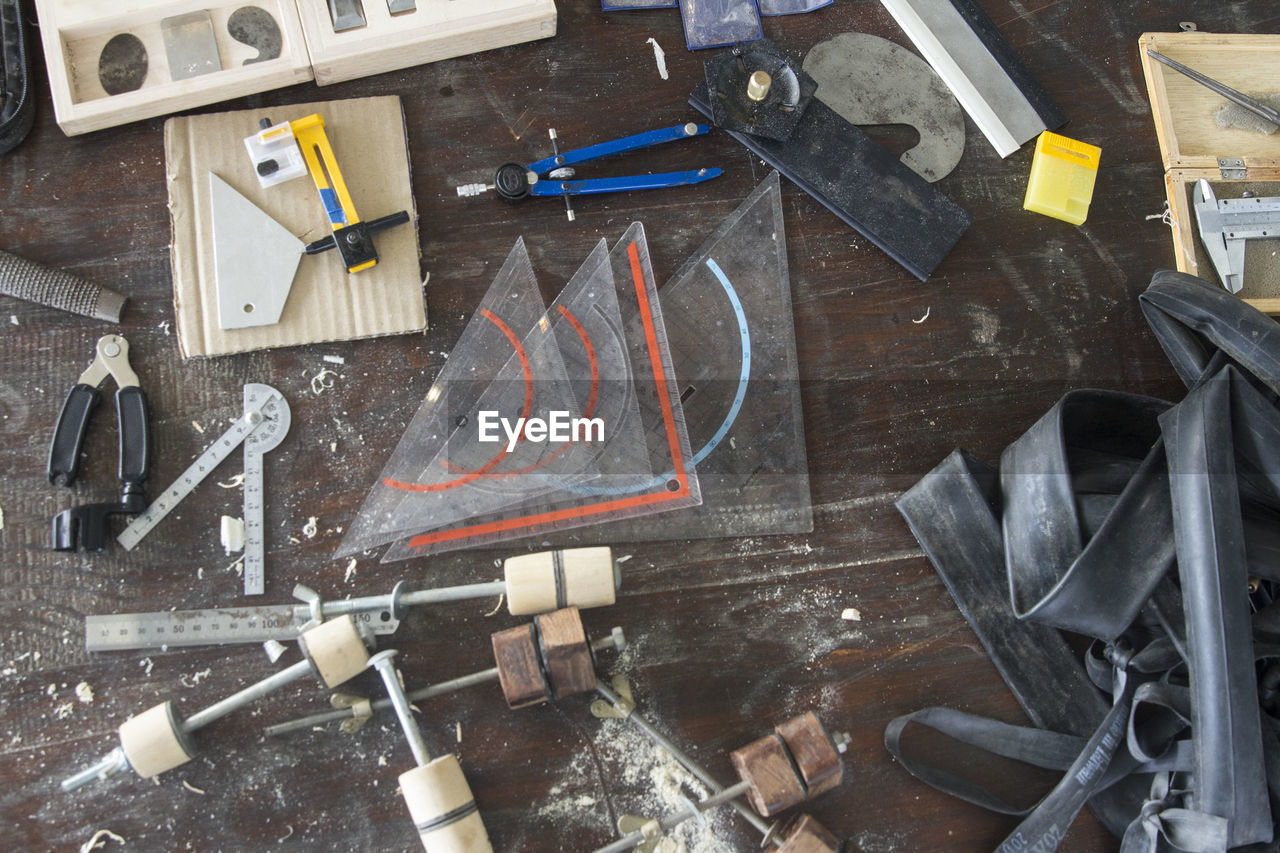 High angle view of work tools on wooden table at workshop