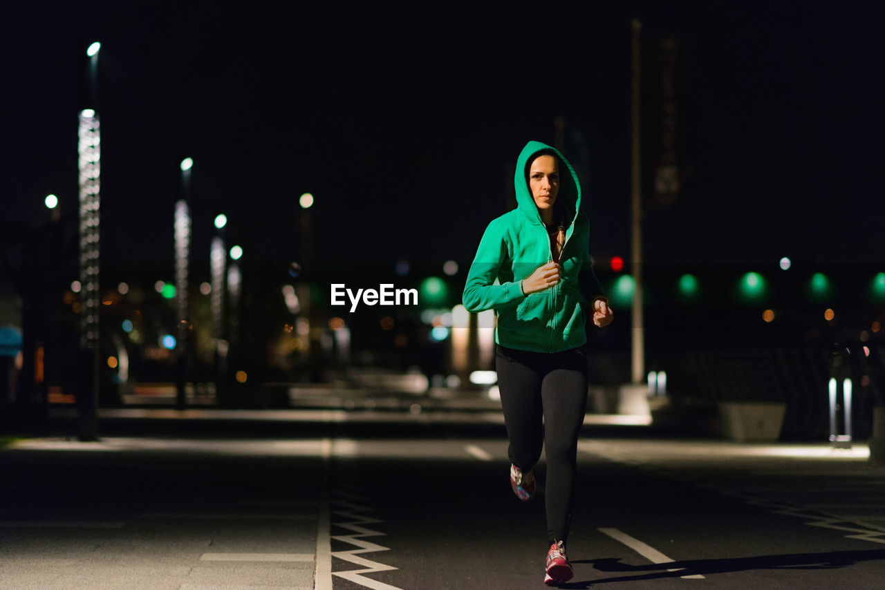 Full length of woman running on road at night