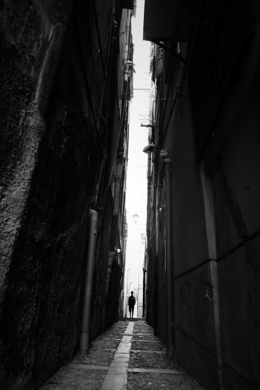 REAR VIEW OF WOMAN WALKING ON ALLEY