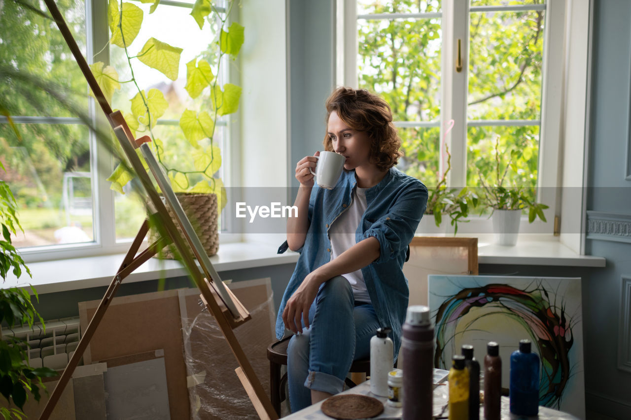 Woman admiring artwork in home studio