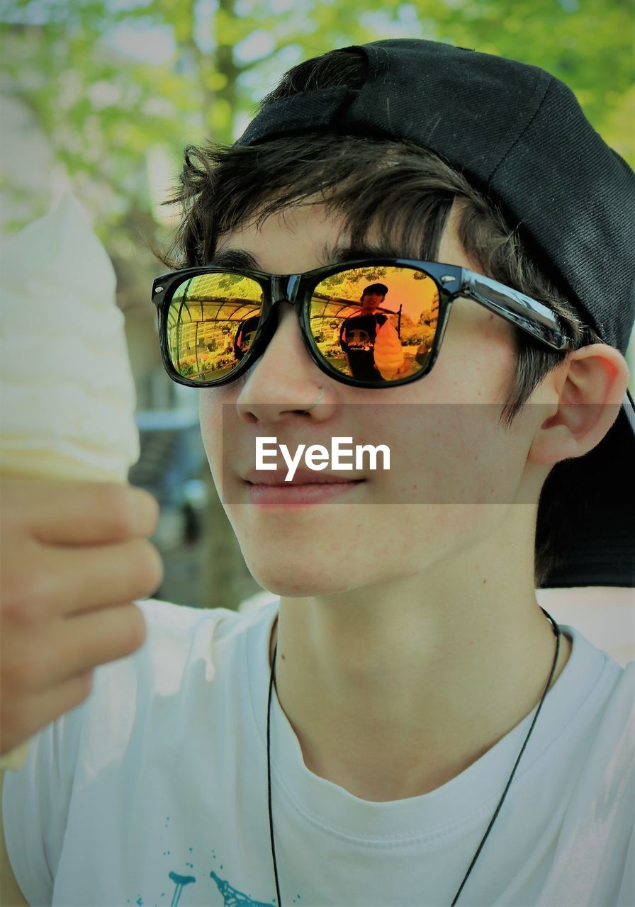Close-up of boy in sunglasses looking at ice cream