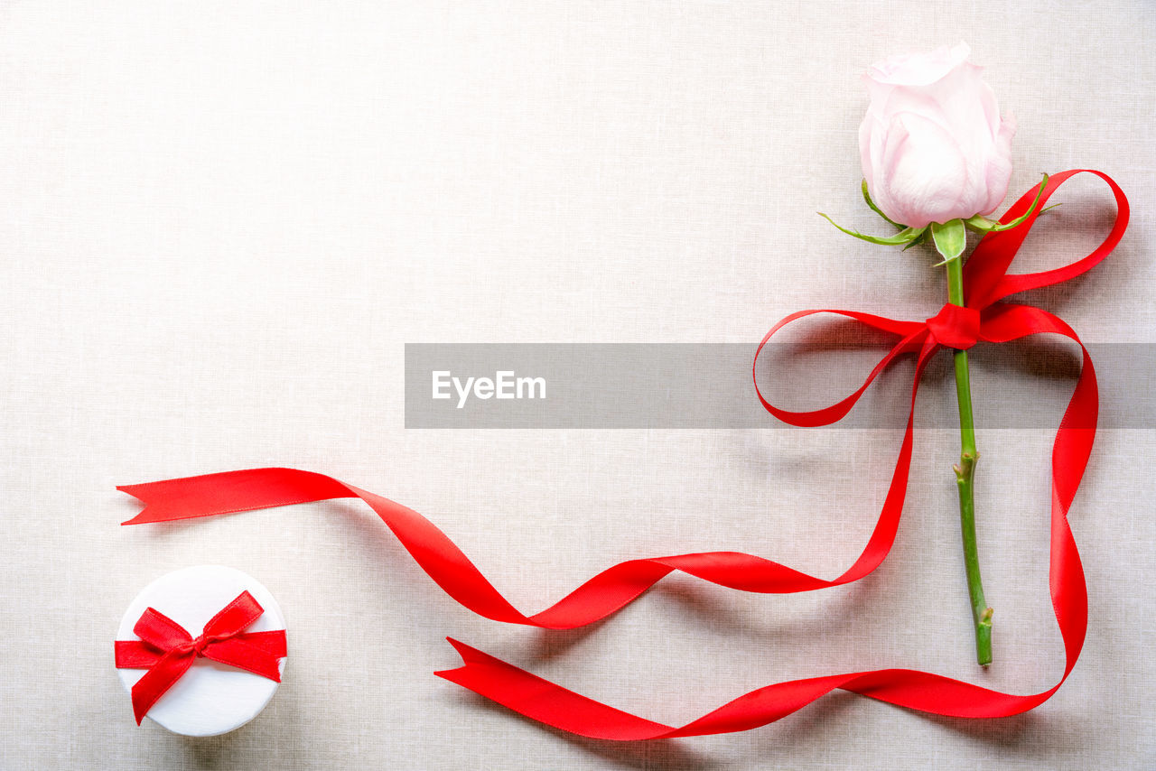 Close-up of rose and gift on table