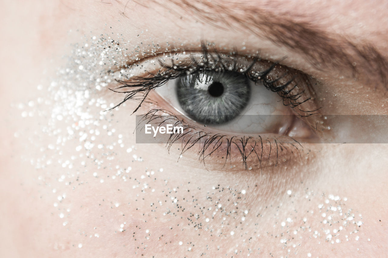 Close-up portrait of woman gray eyes with shimmer make-up