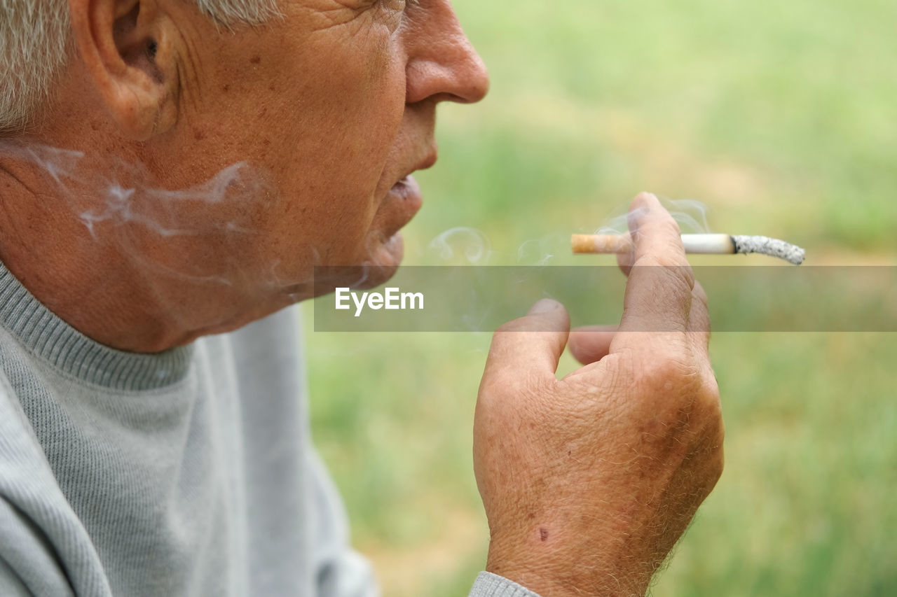 side view of senior man smoking cigarette