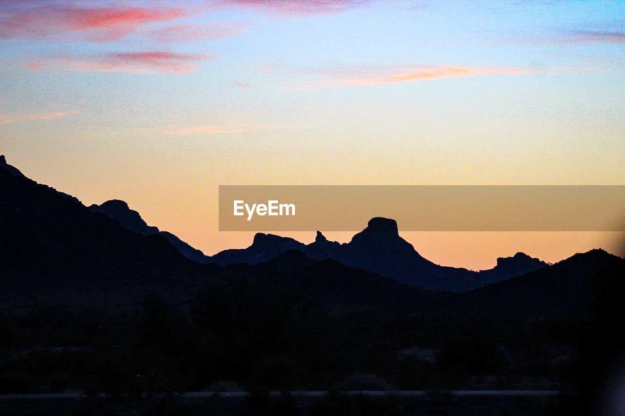 SILHOUETTE MOUNTAIN RANGE AGAINST SKY AT SUNSET