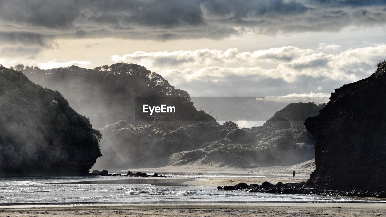 Scenic view of sea and mountains against sky