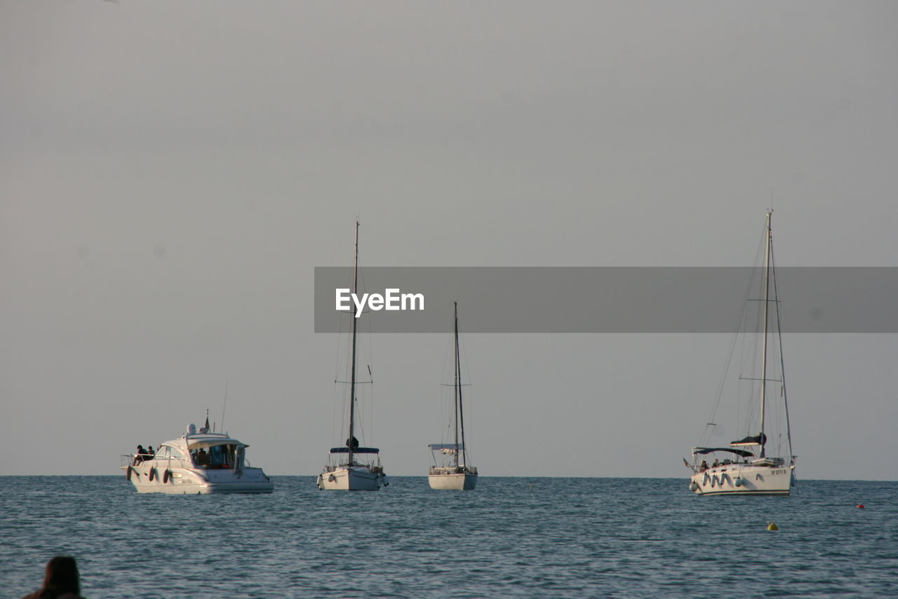 SAILBOAT SAILING IN SEA AGAINST CLEAR SKY