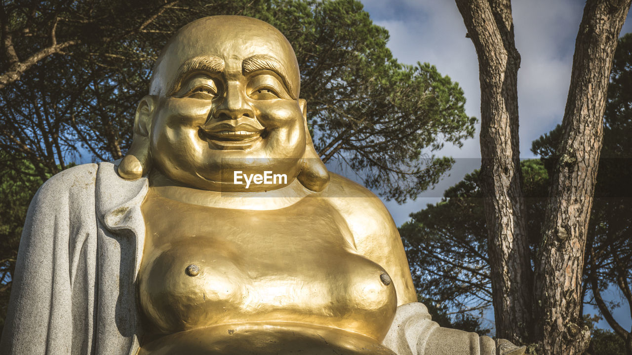 LOW ANGLE VIEW OF STATUE OF BUDDHA