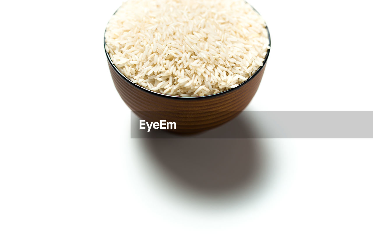 Close-up of rice in bowl over white background