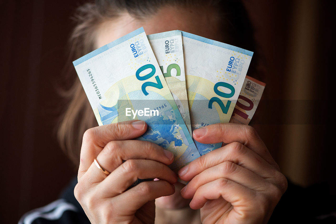 Close-up of woman holding european union currency