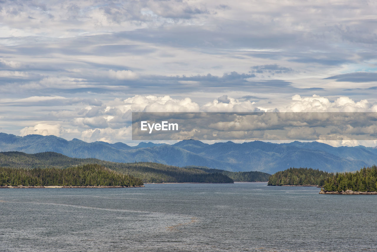 Scenic view of sea and mountains against sky