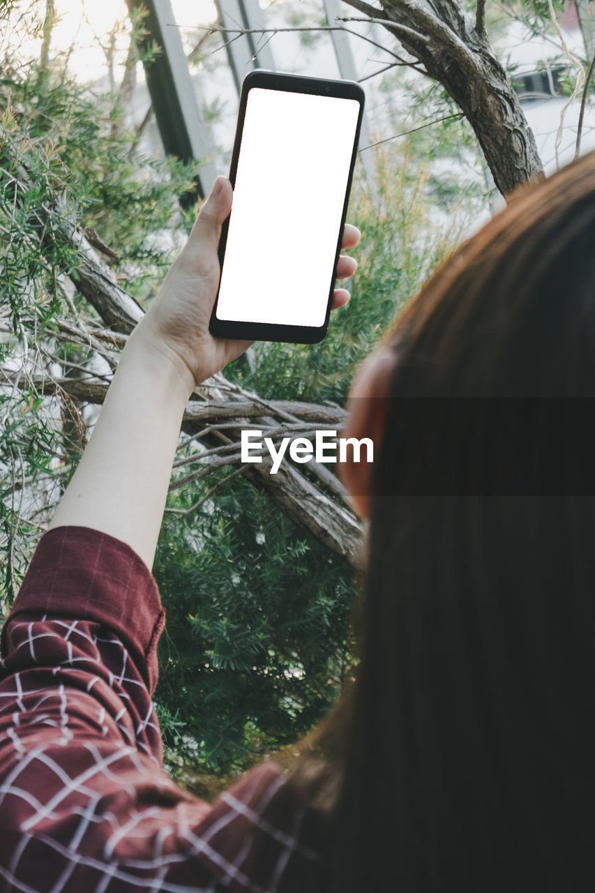 LOW SECTION OF PERSON PHOTOGRAPHING THROUGH MOBILE PHONE
