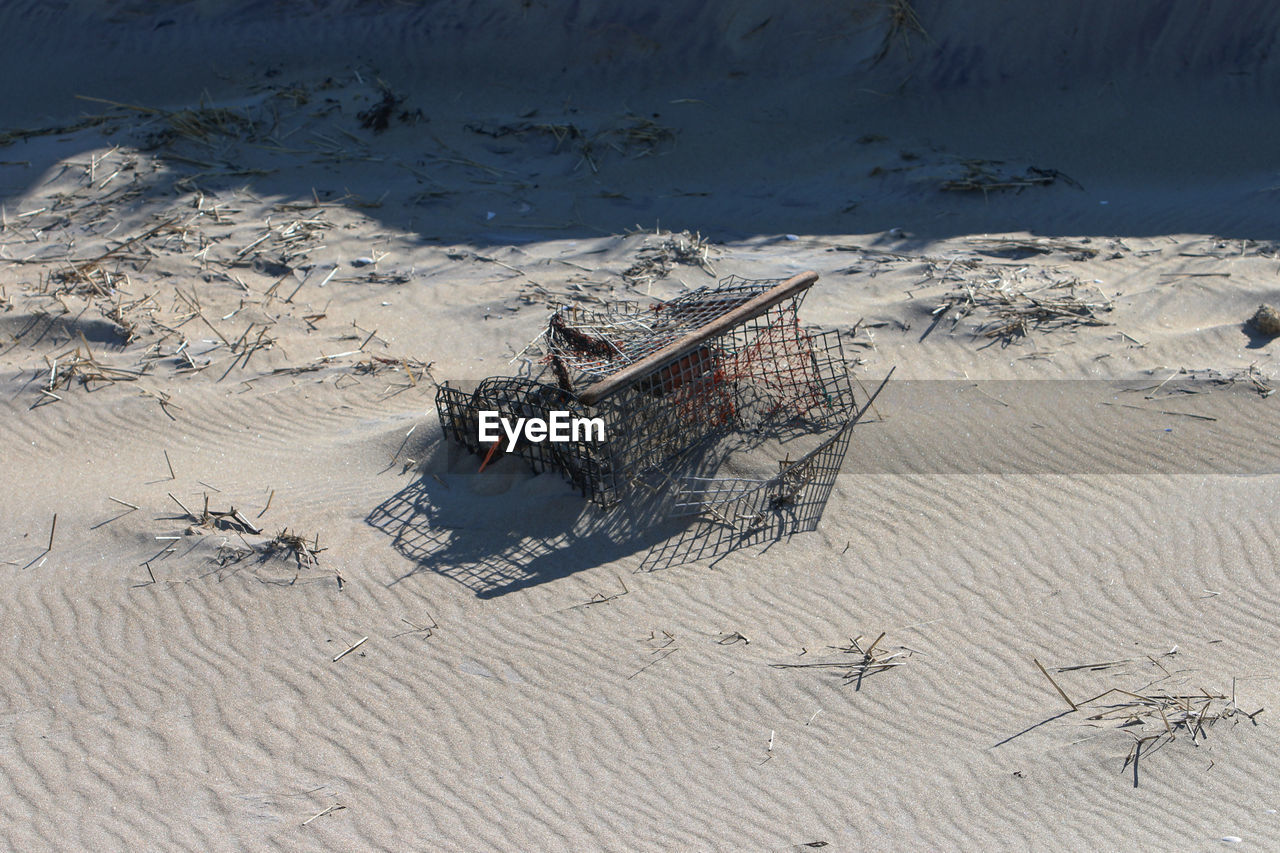 High angle view of a lobster trap washed up on a beach after a storm
