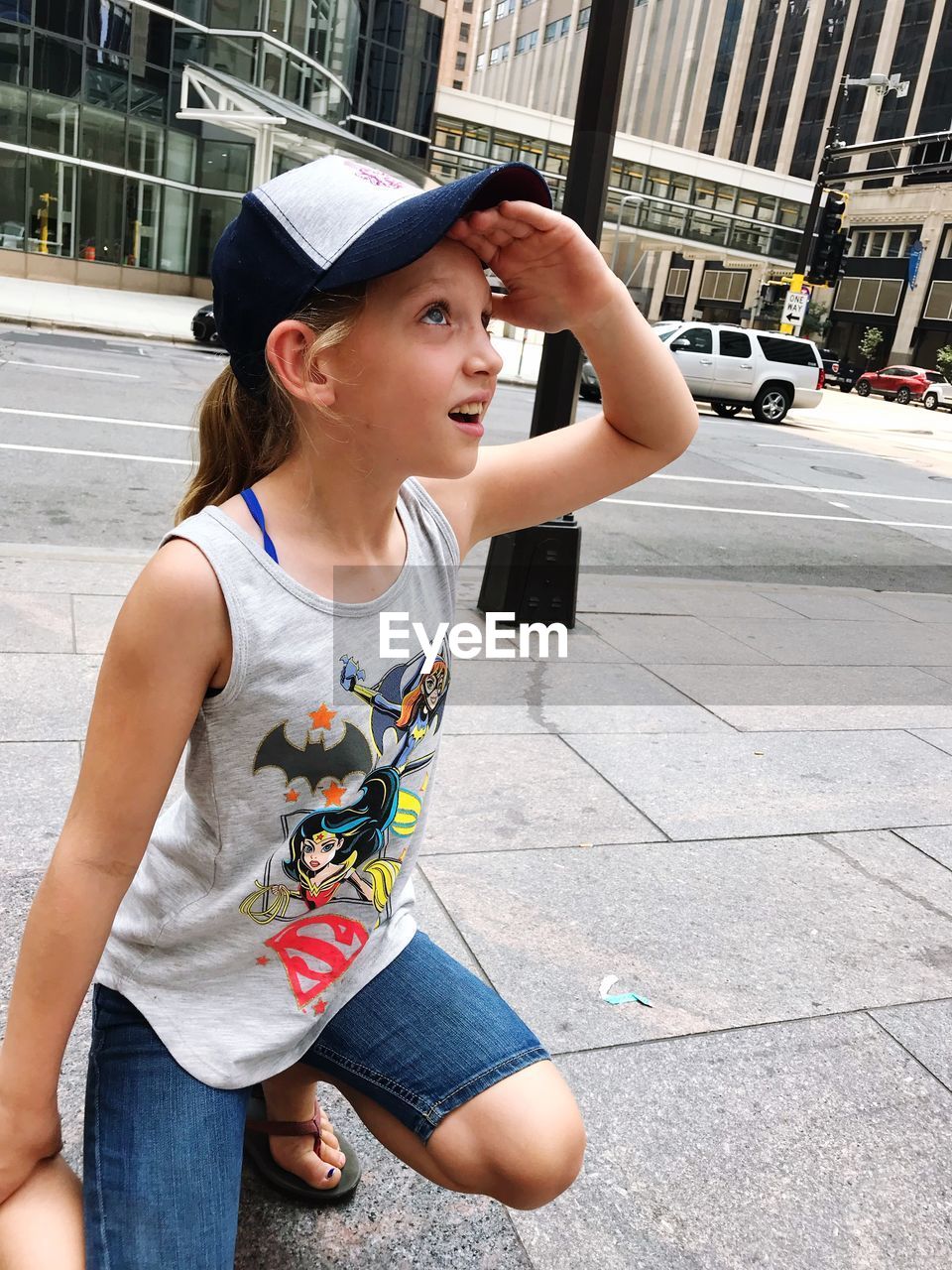 YOUNG WOMAN LOOKING AWAY WHILE STANDING ON STREET