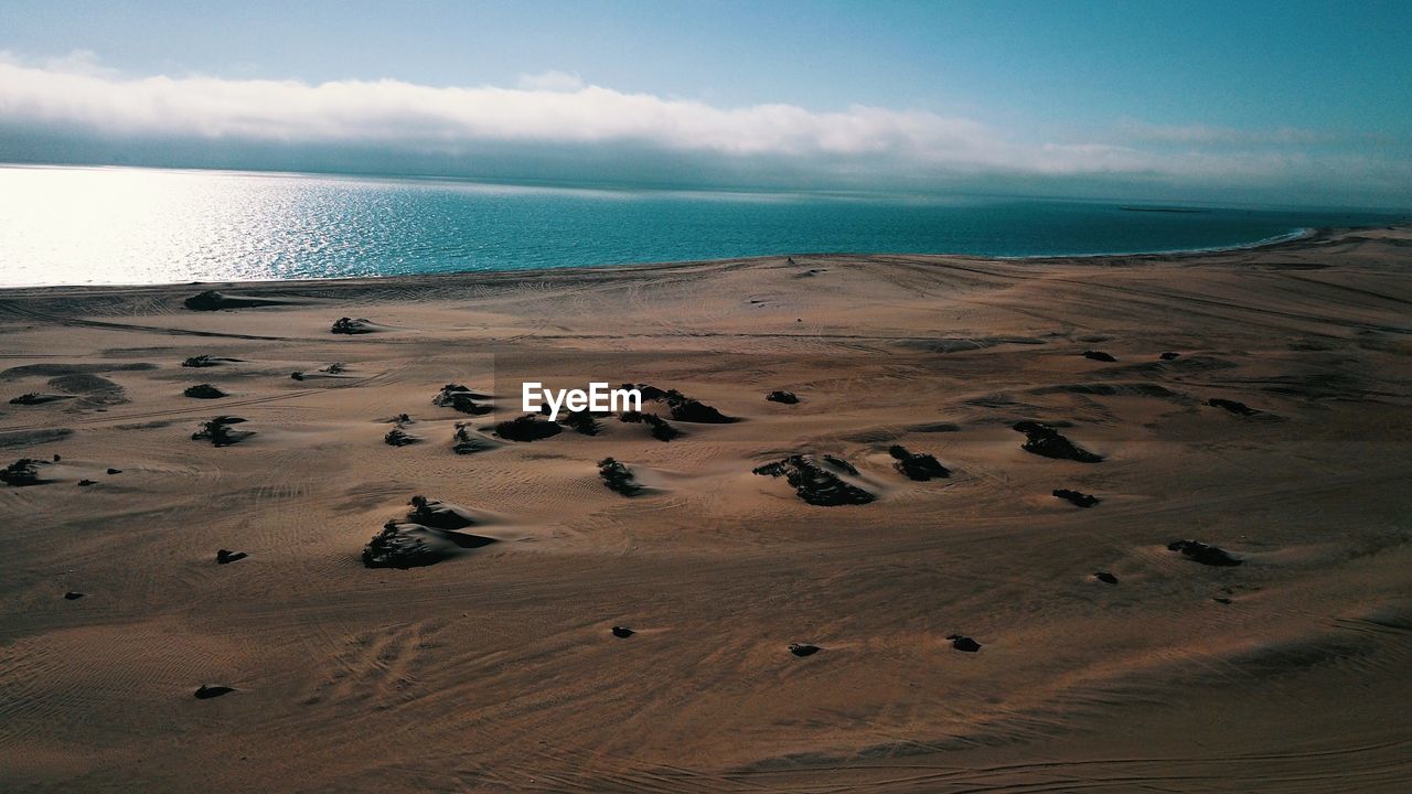 SCENIC VIEW OF SANDY BEACH AGAINST SKY