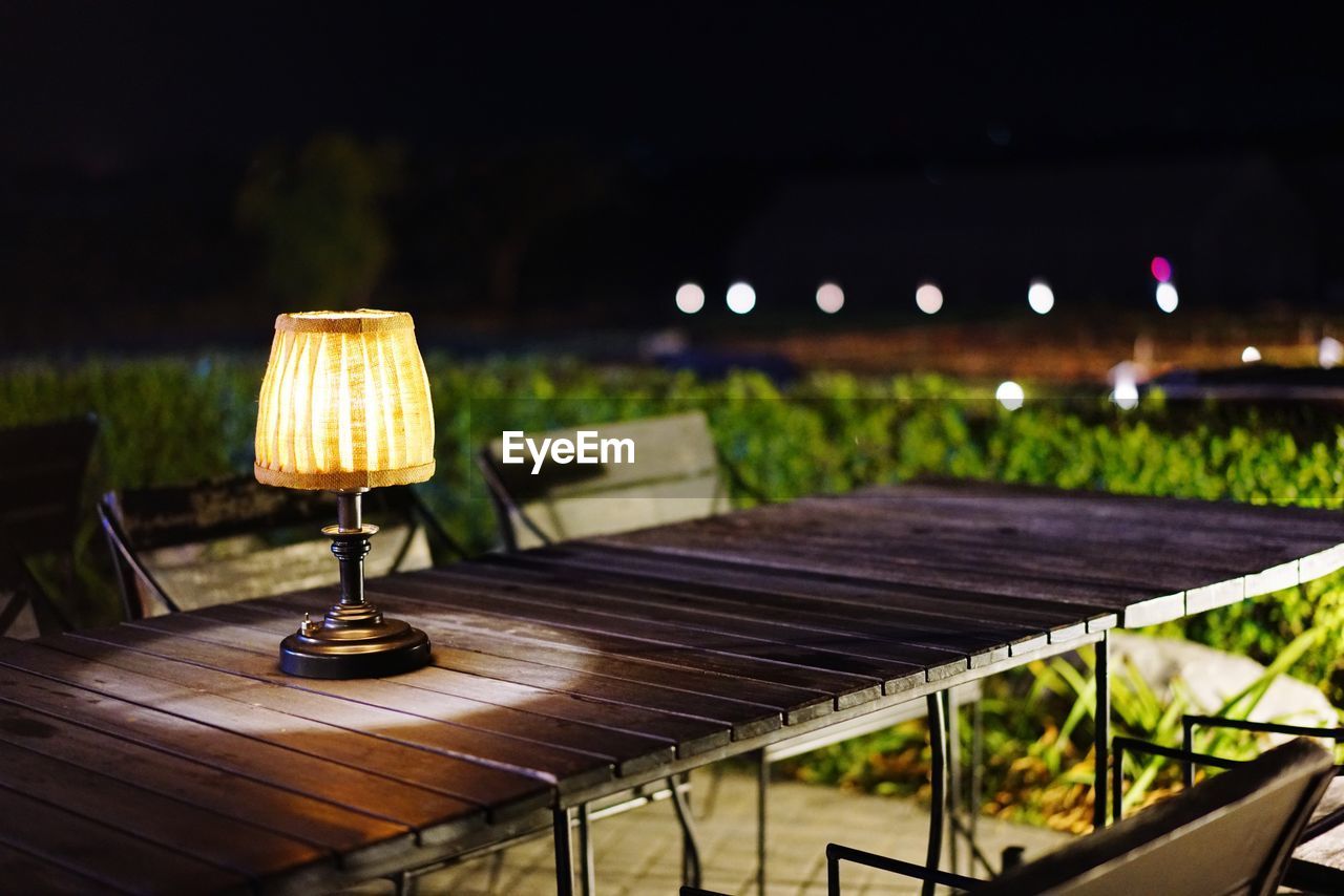 Illuminated electric lamp on table at night