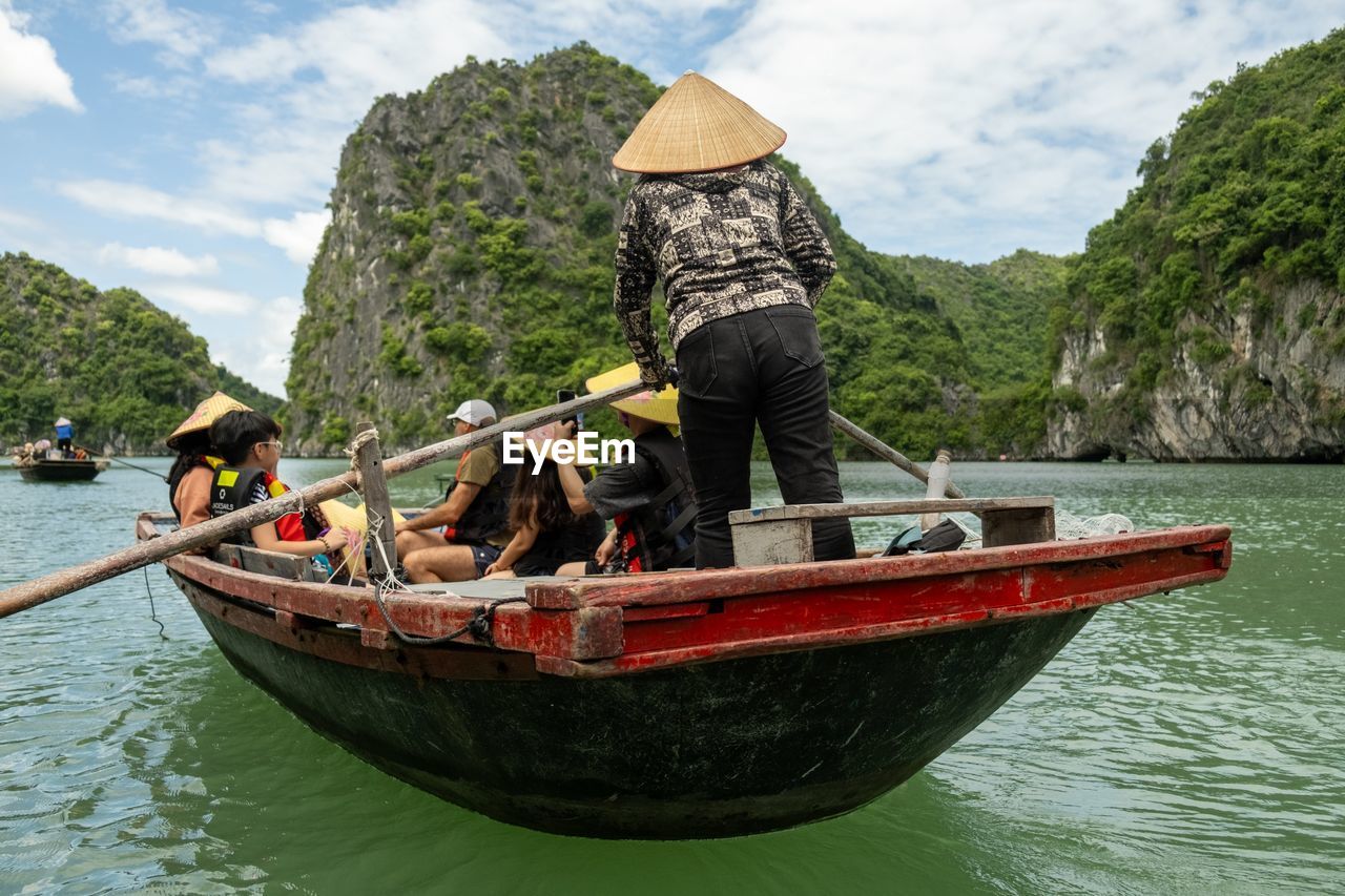 water, nautical vessel, transportation, mode of transportation, boat, nature, vehicle, travel, men, boating, canoe, long-tail boat, adult, sky, group of people, day, trip, holiday, sea, hat, vacation, tree, occupation, travel destinations, watercraft, oar, cloud, outdoors, tourism, plant, tourist, person, mountain, leisure activity, beauty in nature, scenics - nature, journey, activity, waterfront, land, women, lifestyles, adventure, clothing, fishing