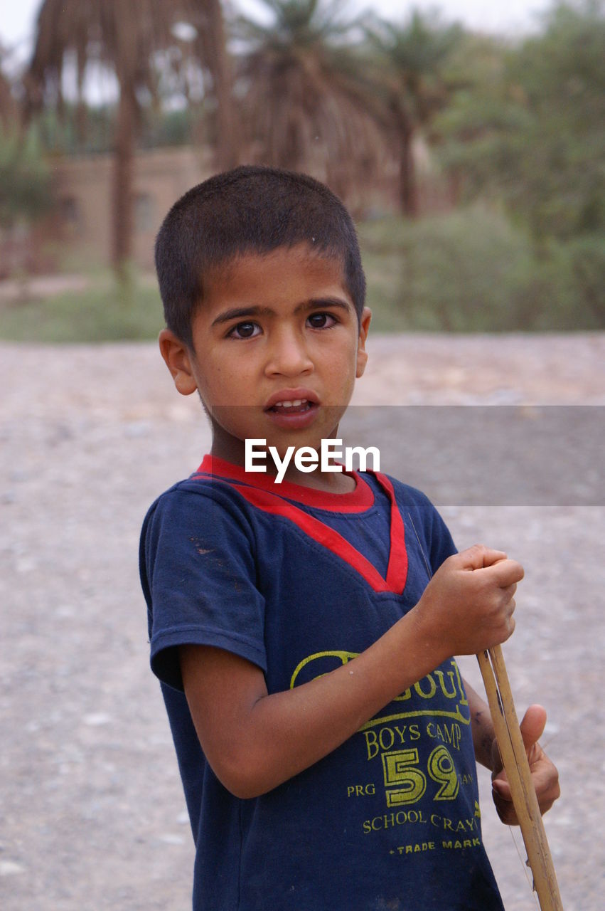 PORTRAIT OF BOY STANDING AT CAMERA