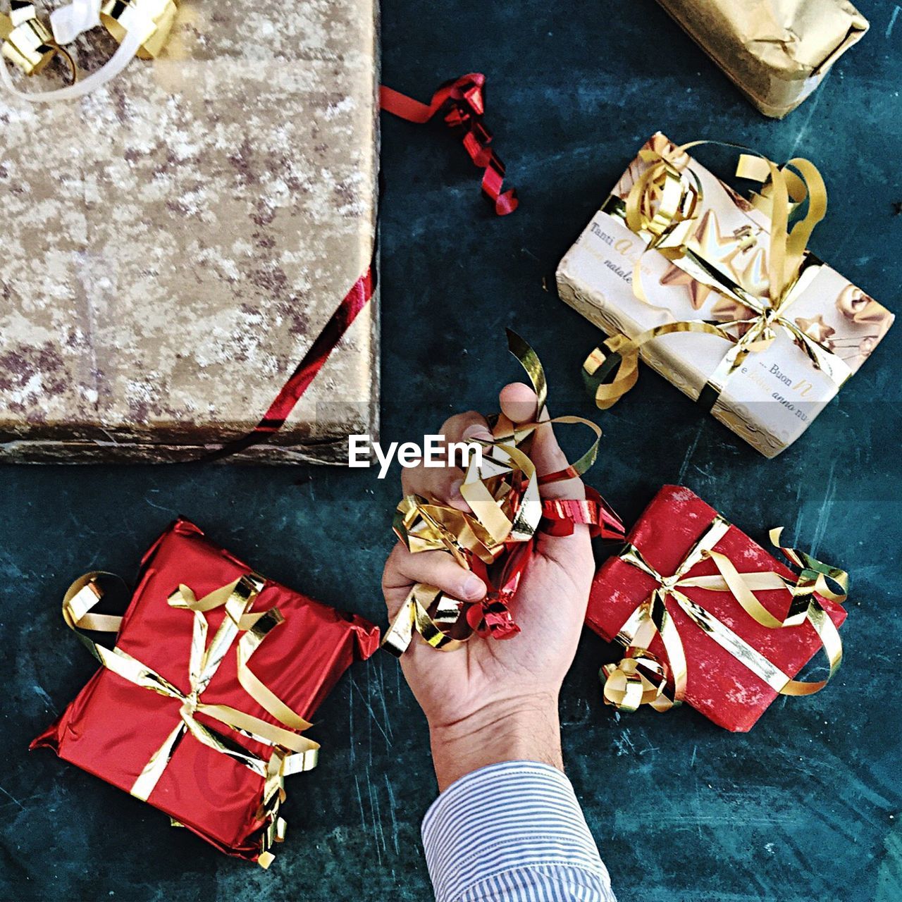 Cropped image of man holding ribbon over table during christmas