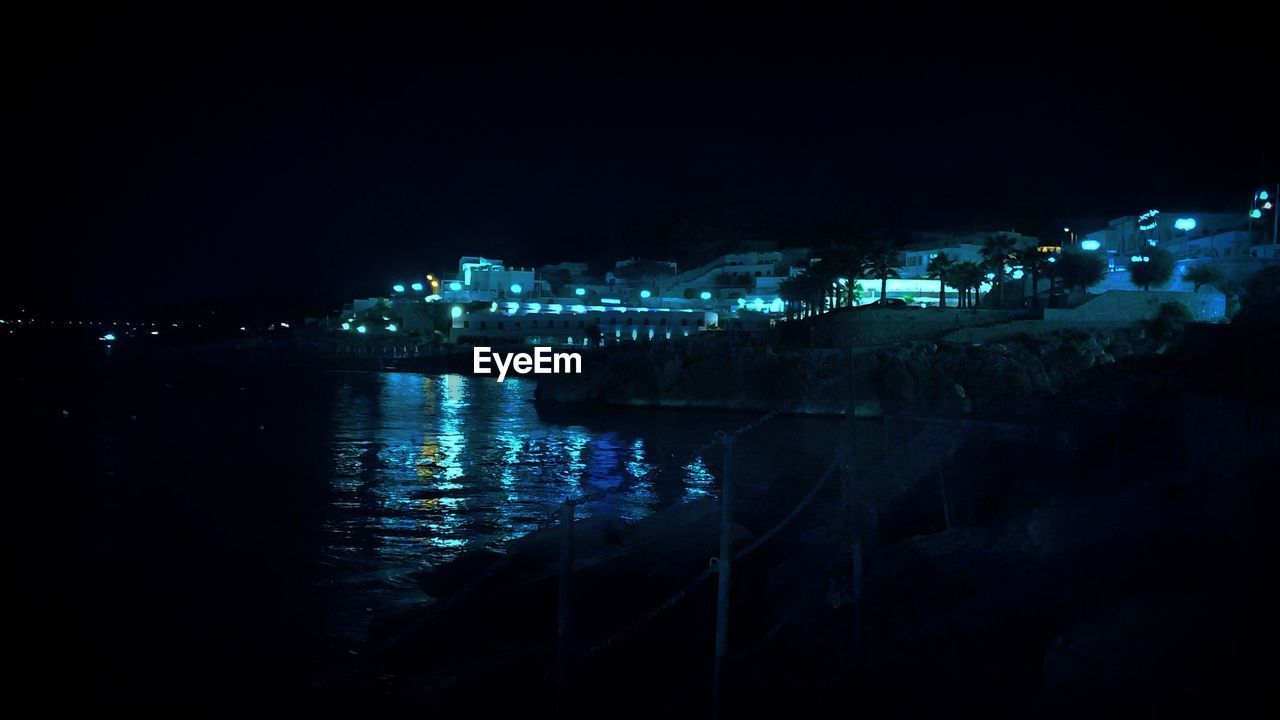 Illuminated cityscape against sky at night