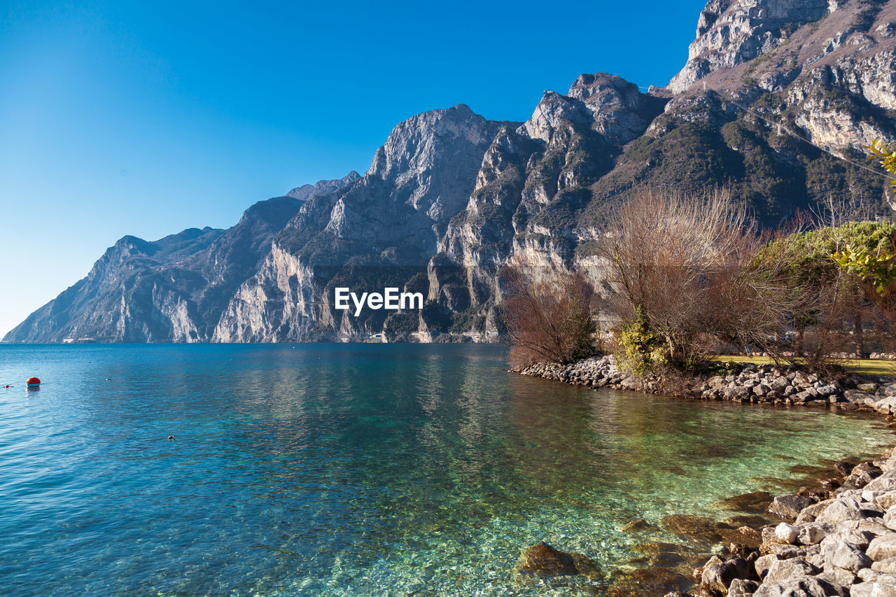 SCENIC VIEW OF SEA AGAINST MOUNTAIN RANGE