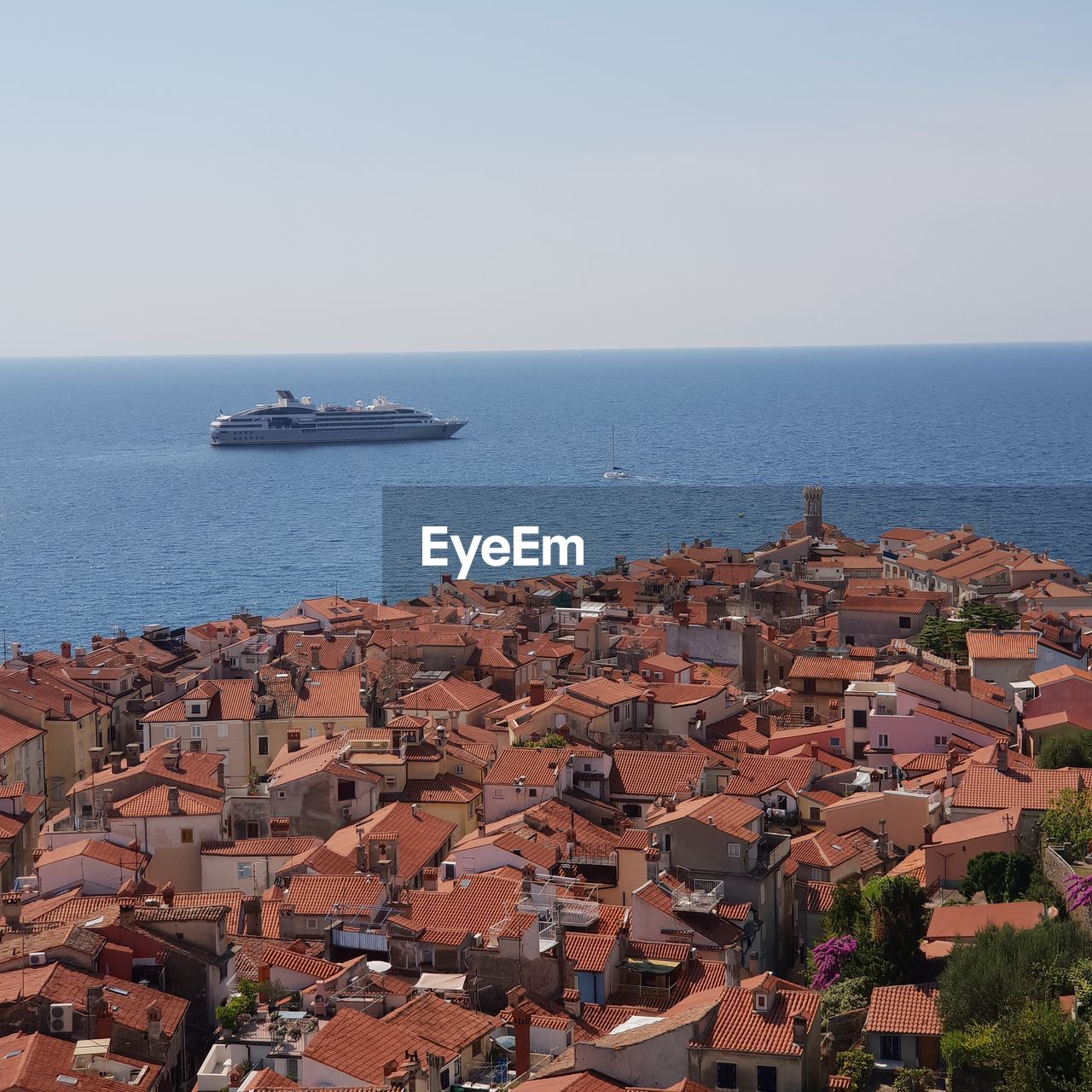 High angle view of sea by buildings against clear sky