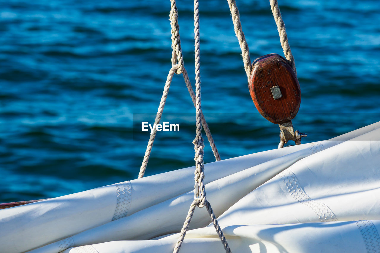Close-up of rope tied to boat moored at sea