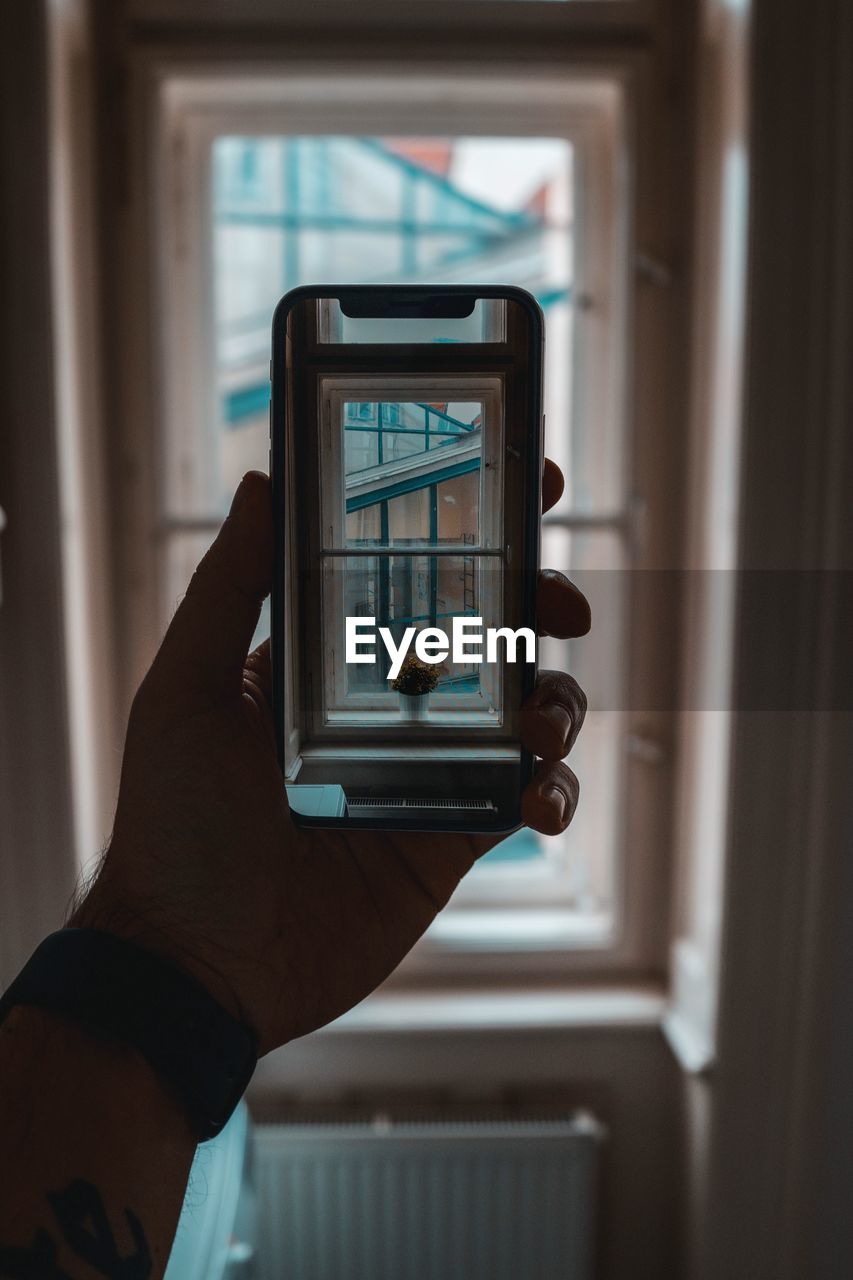 Close-up of man using mobile phone at home