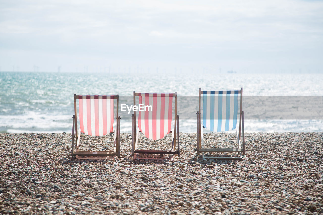 CHAIR ON BEACH AGAINST SKY