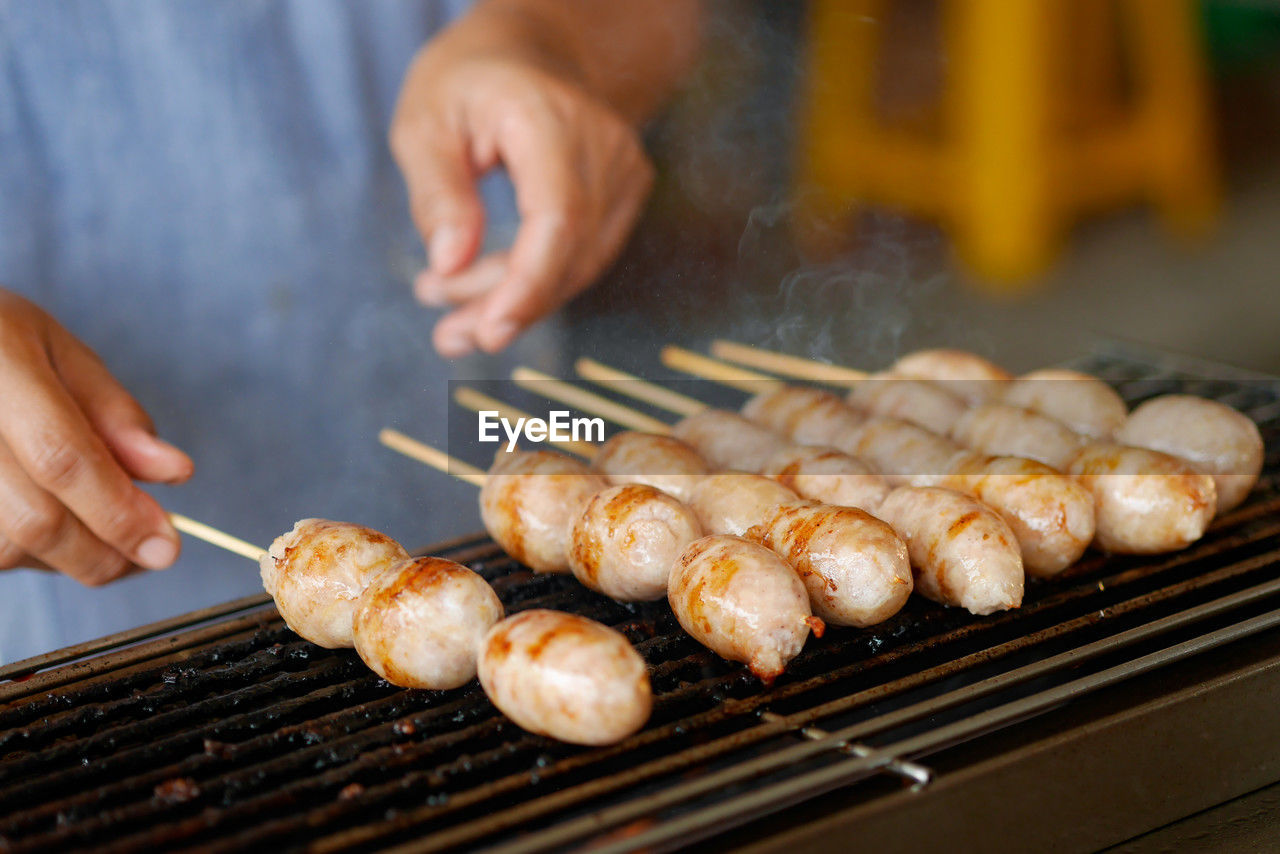 cropped image of man preparing food on barbecue grill