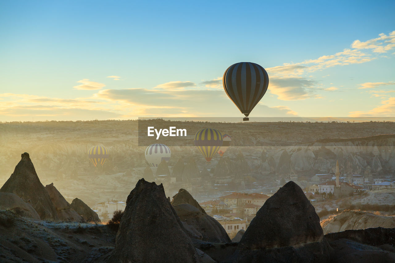 Hot air balloons flying over city