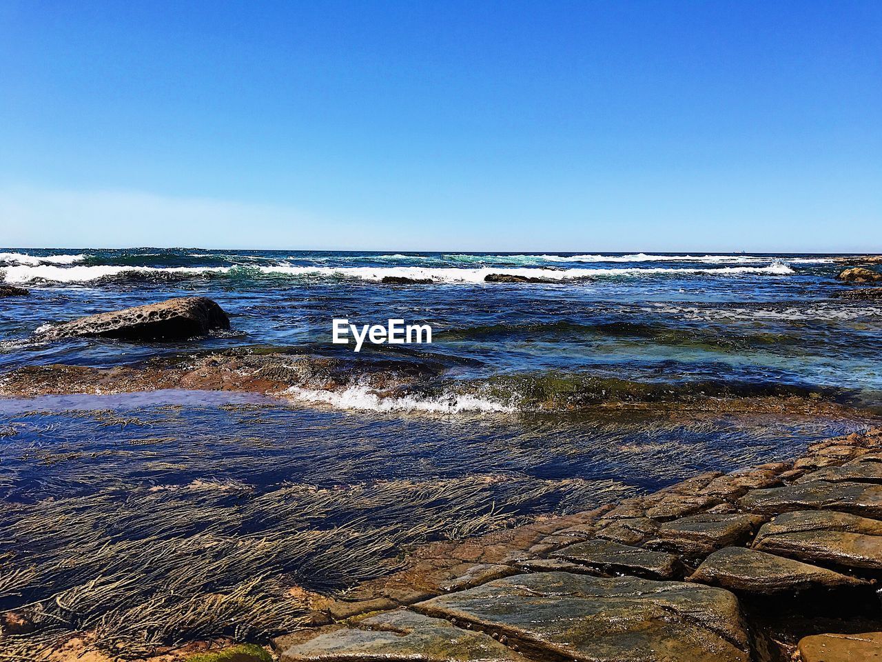 Close-up of sea against clear blue sky