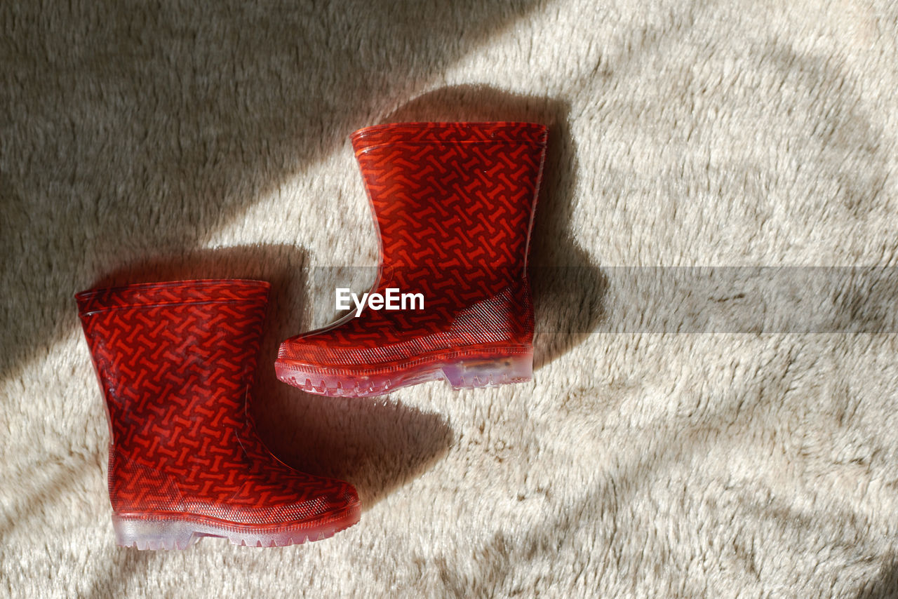 Directly above of shot of red boots on rug