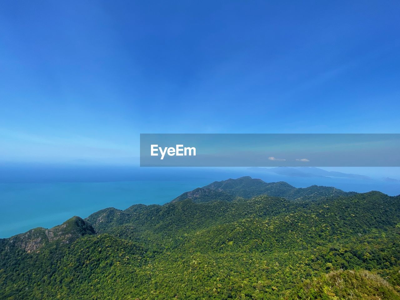 Scenic view of mountains against blue sky