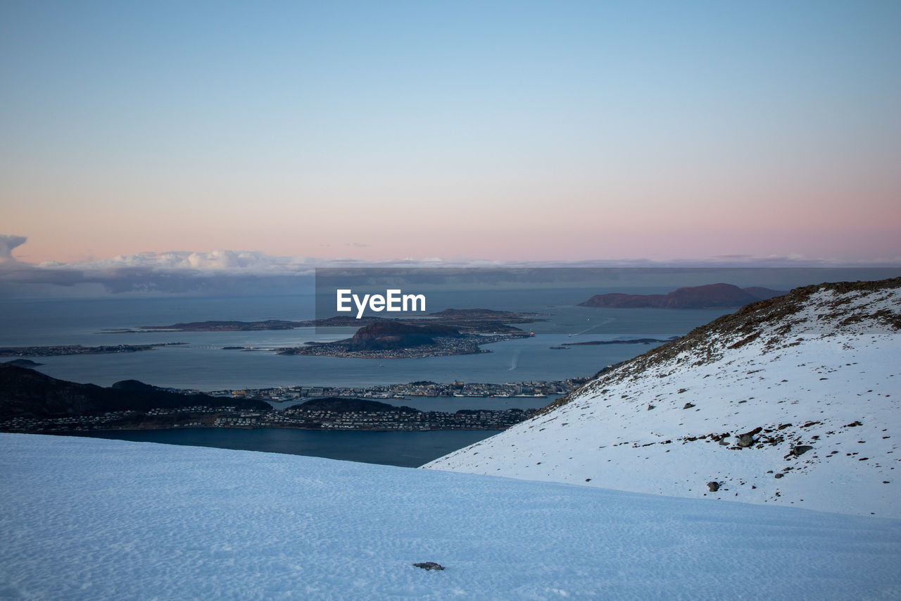 Scenic view of snowcapped mountains against sky during sunset