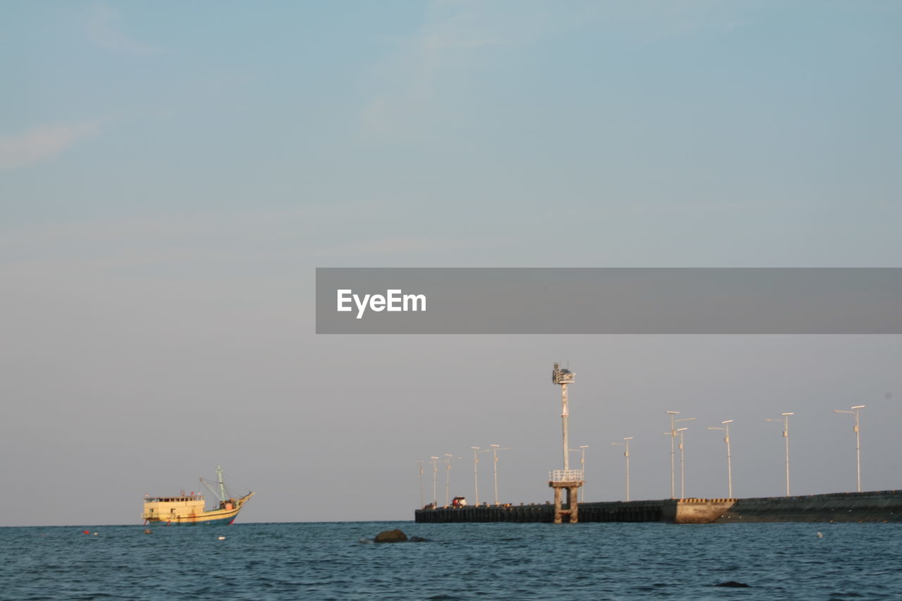 SAILBOAT SAILING IN SEA AGAINST CLEAR SKY