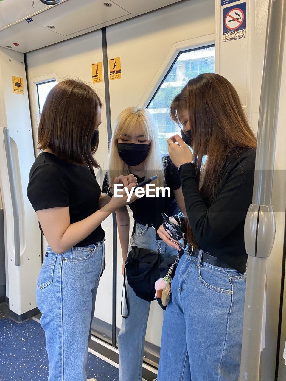 Women wearing masks standing in subway train